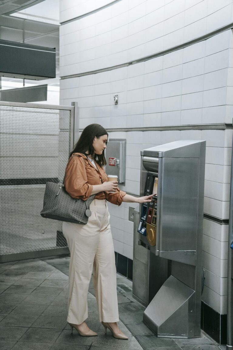 A woman purchasing a ticket at a subway station ticket machine, indoors.